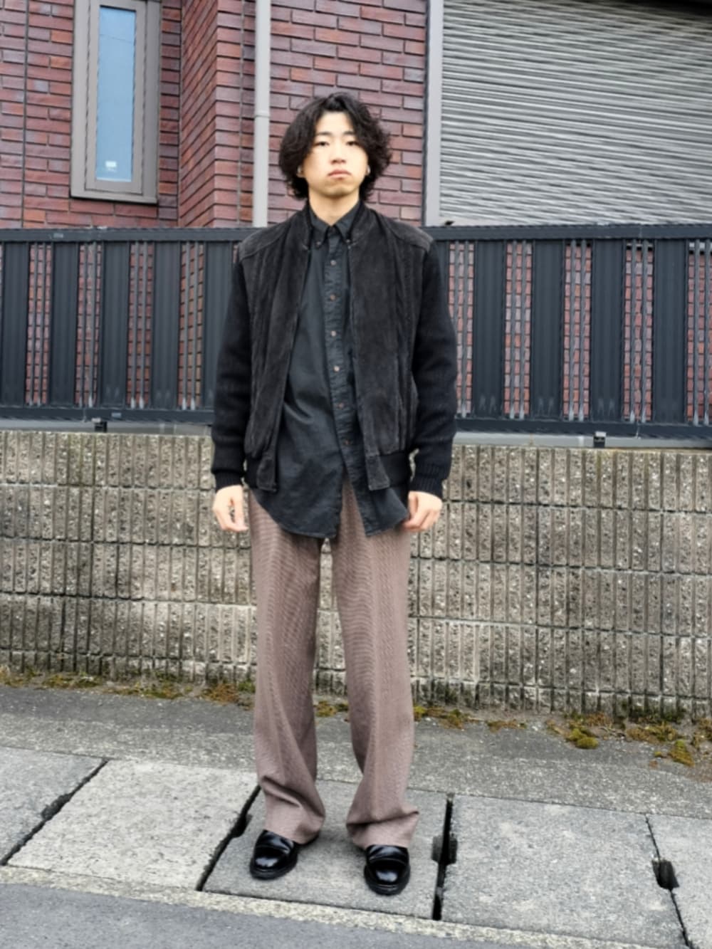 ブラック系のジャケット/アウター、ブラック系のシャツ/ブラウス、ブラウン系のスラックスを着用したメンズの冬コーディネートの3枚目の写真