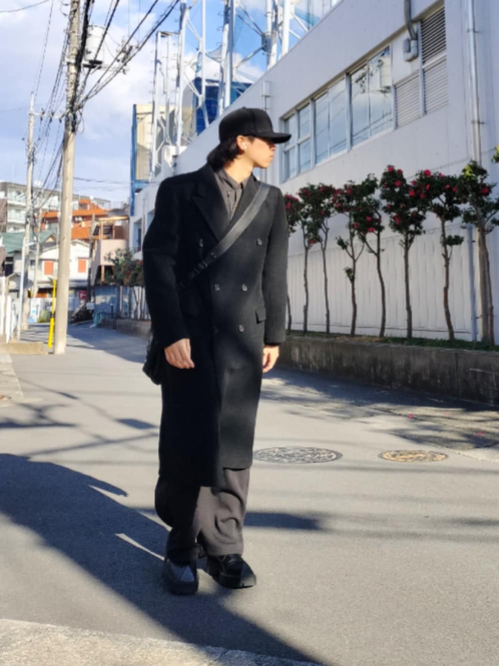 ブラック系のステンカラーコート、ブラック系のスウェットパンツ、ブラック系のドレスシューズを着用したメンズの冬コーディネートの2枚目の写真