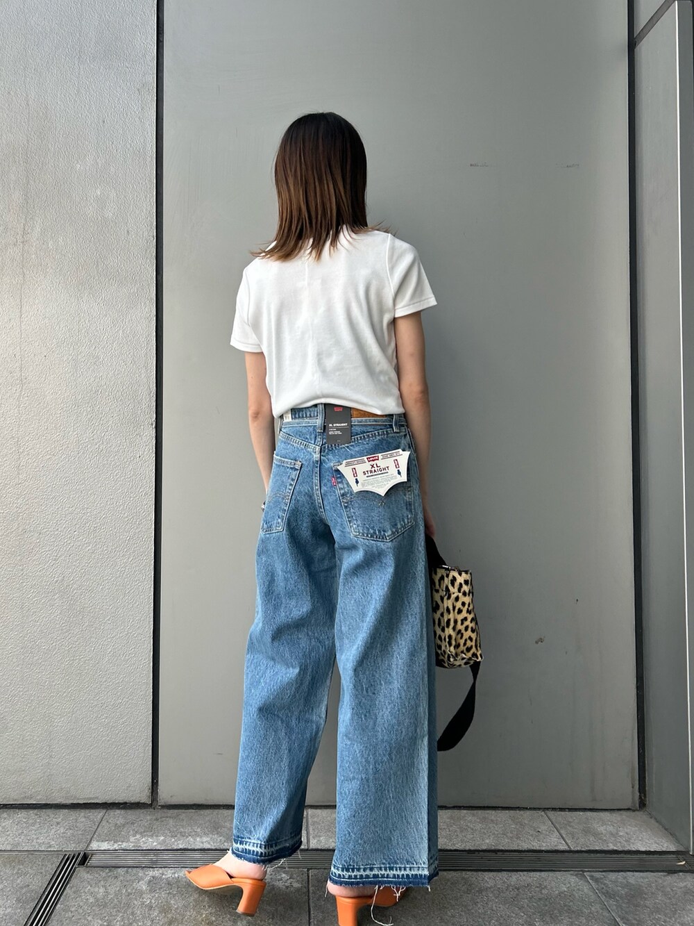 ホワイト系のTシャツ/カットソー、ブルー系のデニムパンツ、ブラック系のサングラスを着用したレディースの夏コーディネートの3枚目の写真
