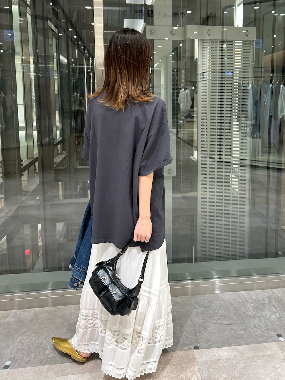 グレー系のTシャツ/カットソー、ホワイト系のスカート、ブルー系のデニムジャケットを着用したレディースの夏コーディネートの3枚目の写真