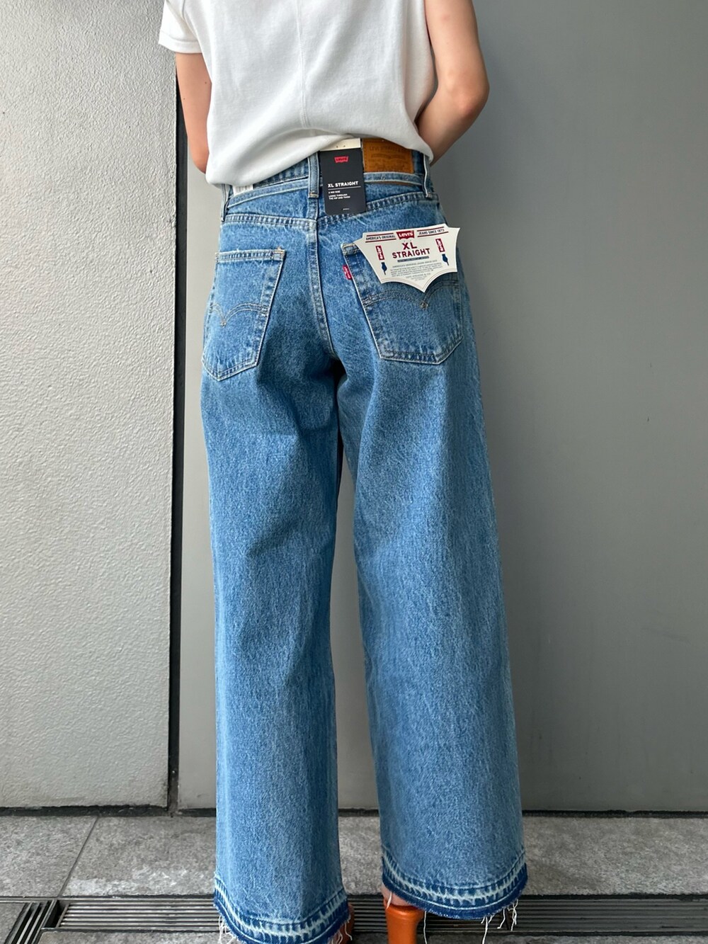 ホワイト系のTシャツ/カットソー、ブルー系のデニムパンツ、ブラック系のサングラスを着用したレディースの夏コーディネートの5枚目の写真