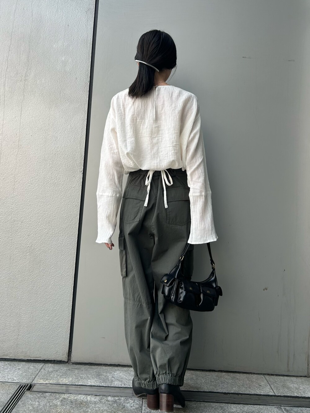 ホワイト系のシャツ/ブラウス、グリーン系のカーゴパンツ、ブラック系のハンドバッグを着用したレディースの夏コーディネートの3枚目の写真
