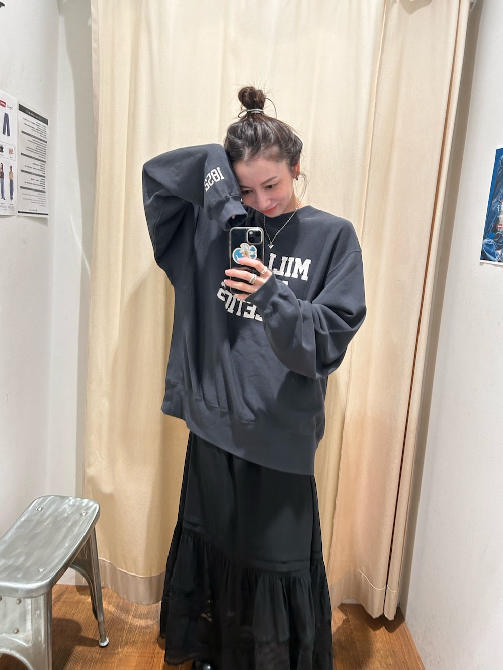 ブラック系のベスト、グレー系のスウェット、ブラック系のスカートを着用したレディースの秋コーディネートの3枚目の写真