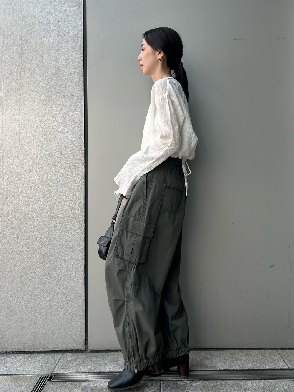 ホワイト系のシャツ/ブラウス、グリーン系のカーゴパンツ、ブラック系のハンドバッグを着用したレディースの夏コーディネートの2枚目の写真
