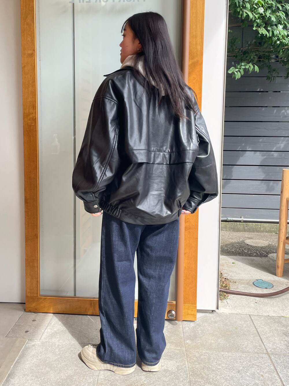 グレー系のパーカー、ブラック系のライダースジャケット、ブルー系のニット/セーターを着用したレディースの秋コーディネートの2枚目の写真