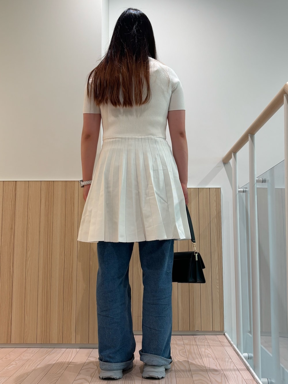 ホワイト系のワンピース、ブルー系のデニムパンツ、グレー系のスニーカーを着用したレディースの夏コーディネートの2枚目の写真