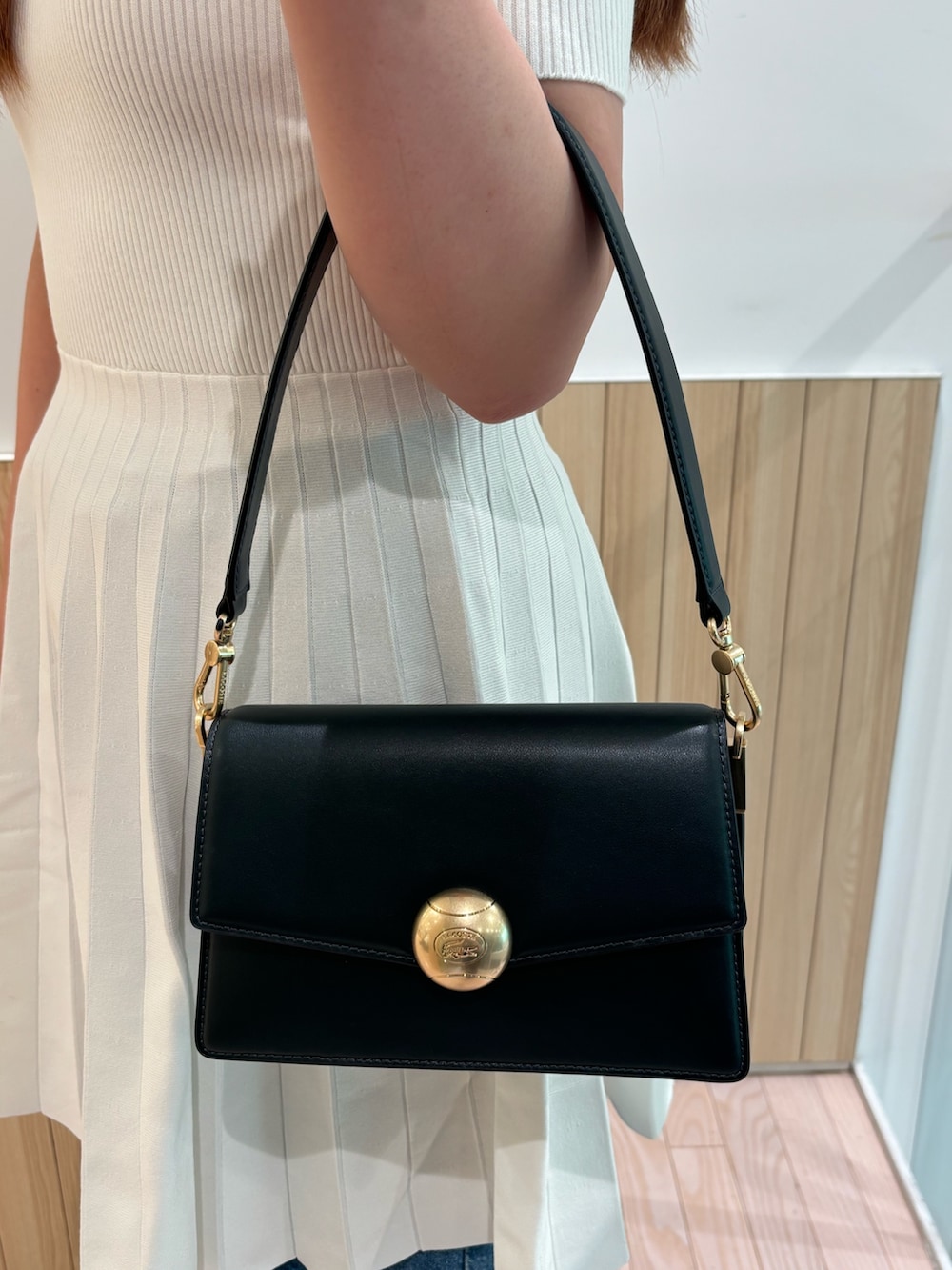 ホワイト系のワンピース、ブルー系のデニムパンツ、グレー系のスニーカーを着用したレディースの夏コーディネートの4枚目の写真
