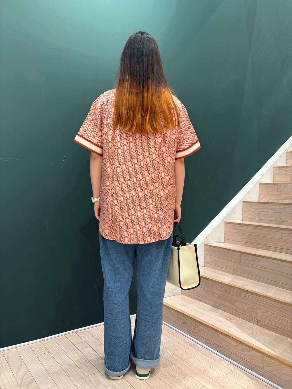 ピンク系のシャツ/ブラウス、ブルー系のデニムパンツ、ホワイト系のスニーカーを着用したレディースの春コーディネートの2枚目の写真