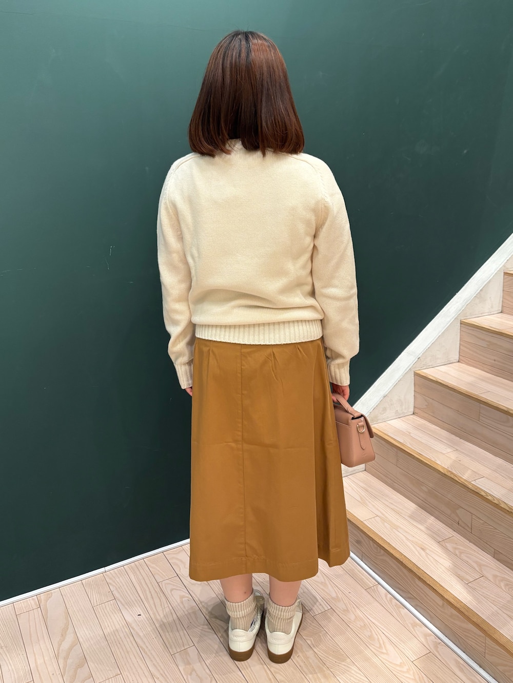ホワイト系のニット/セーター、イエロー系のスカート、ピンク系のハンドバッグを着用したレディースの秋コーディネートの2枚目の写真
