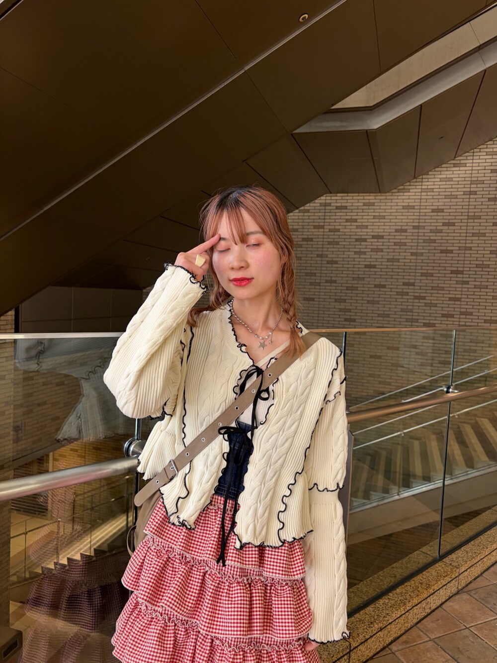 ホワイト系のカーディガン/ボレロ、レッド系のジャンパースカートを着用したレディースの春コーディネートの6枚目の写真