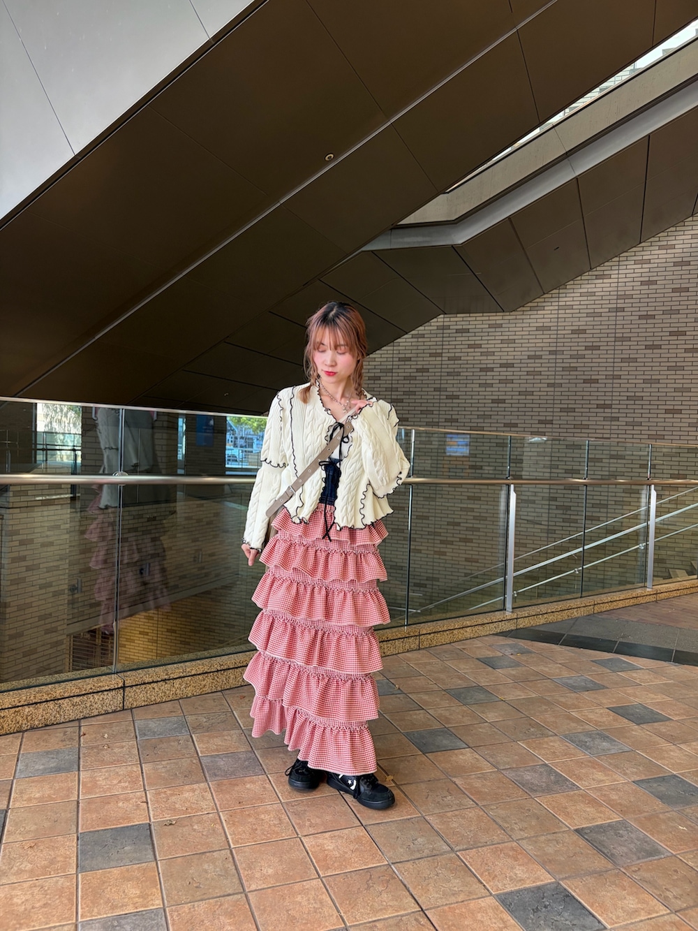 ホワイト系のカーディガン/ボレロ、レッド系のジャンパースカートを着用したレディースの春コーディネートの2枚目の写真