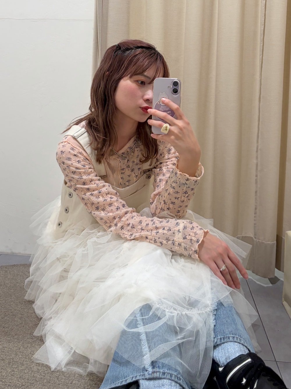 ホワイト系のジャンパースカート、ピンク系のTシャツ/カットソー、ブルー系のデニムパンツを着用したレディースの春コーディネートの2枚目の写真