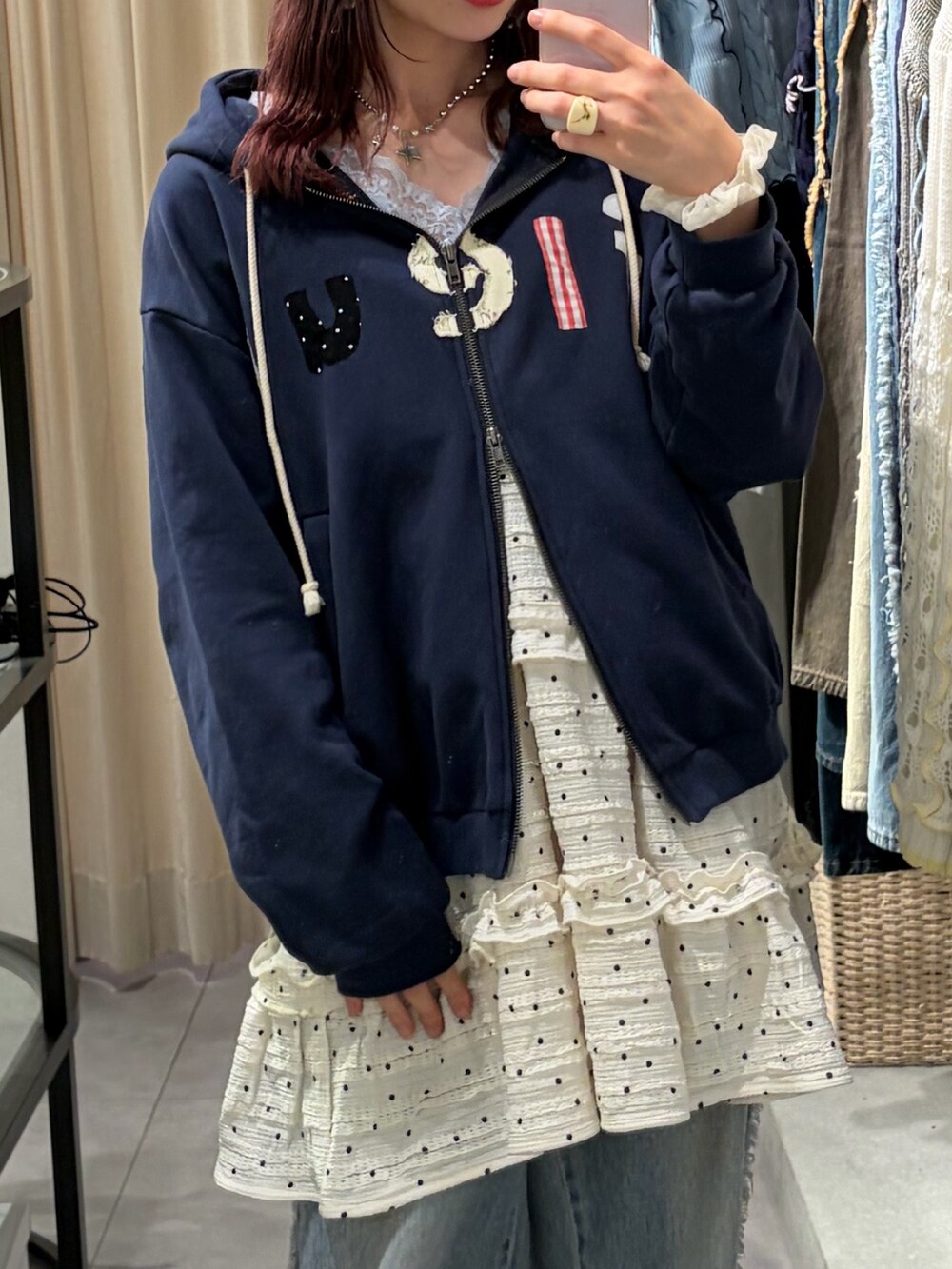 ブルー系のパーカー、ホワイト系のワンピース、ブルー系のデニムパンツを着用したレディースの春コーディネートの2枚目の写真