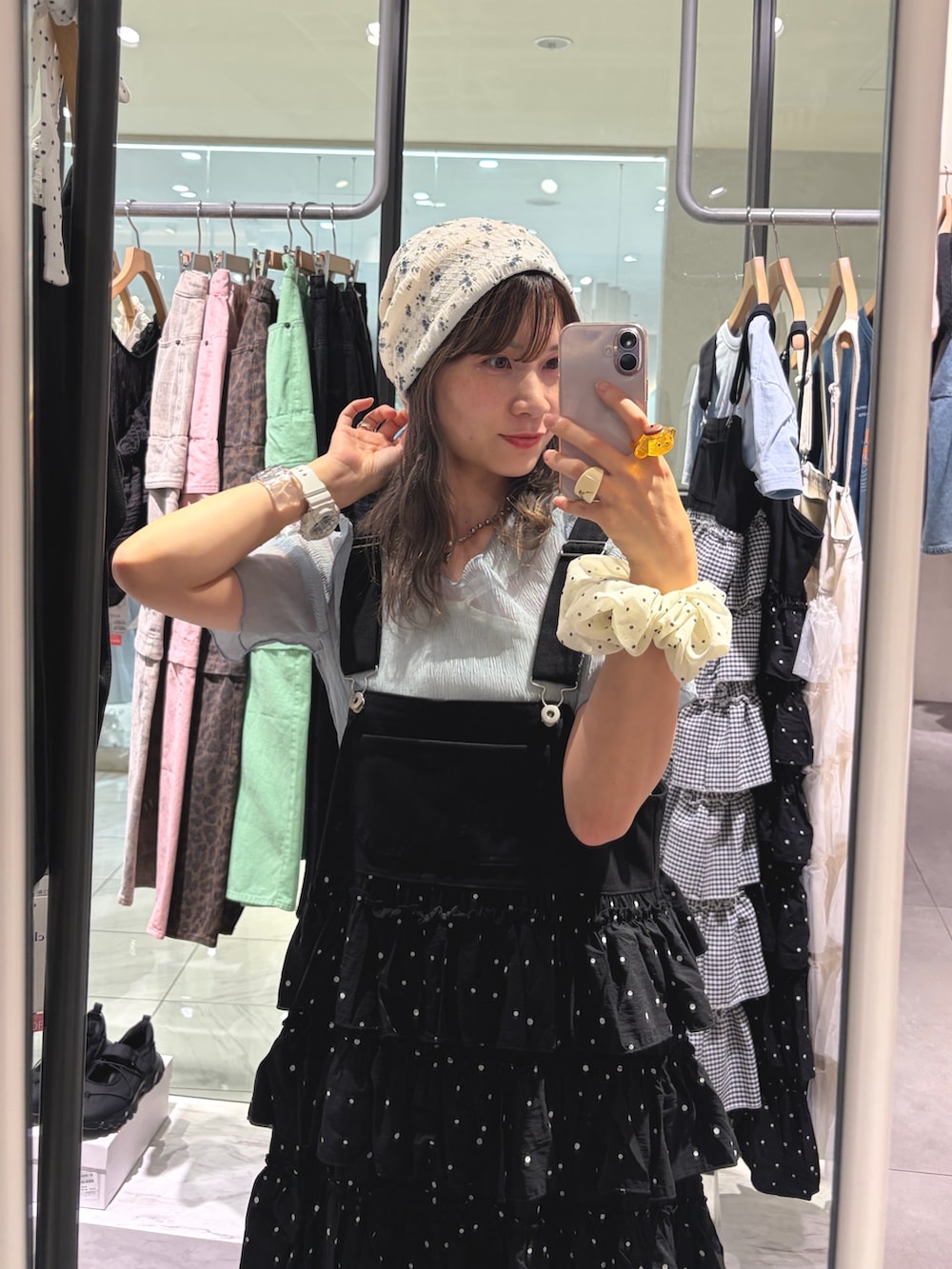 ブラック系のジャンパースカート、ブルー系のシャツ/ブラウス、ホワイト系のキャップを着用したレディースの夏コーディネートの2枚目の写真