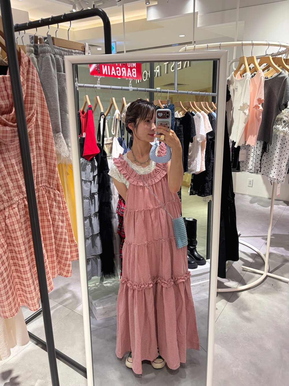 レッド系のワンピース、ホワイト系のTシャツ/カットソーを着用したレディースの夏コーディネートの2枚目の写真