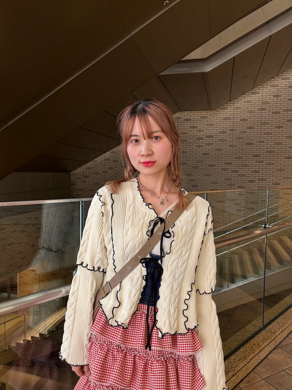 ホワイト系のカーディガン/ボレロ、レッド系のジャンパースカートを着用したレディースの春コーディネートの7枚目の写真