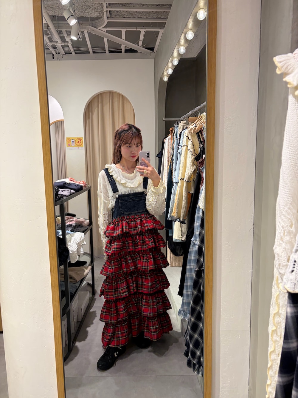 ホワイト系のパーカー、レッド系のジャンパースカートを着用したレディースの春コーディネートの2枚目の写真