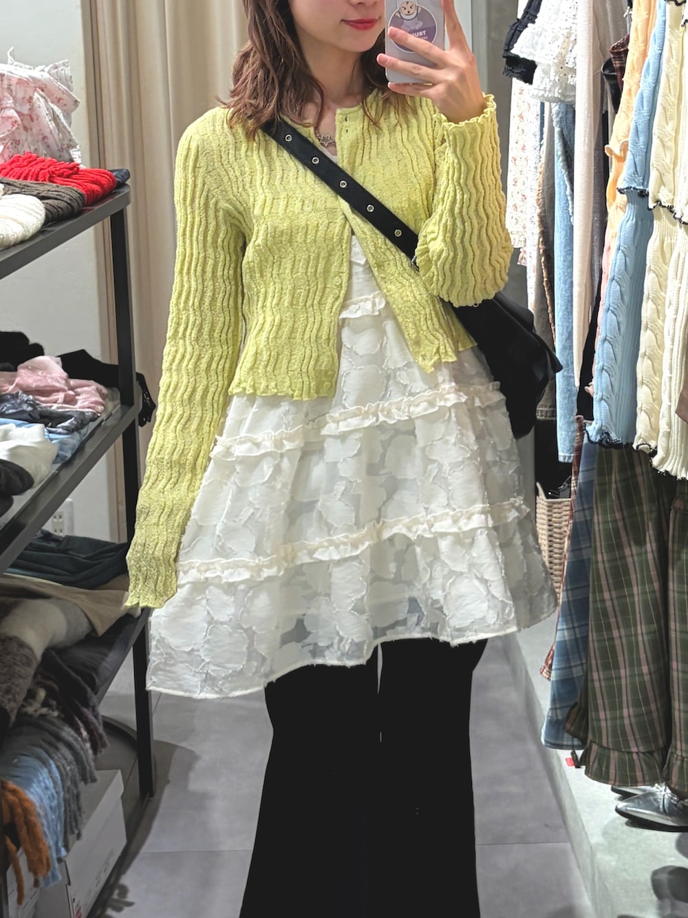 グリーン系のTシャツ/カットソー、ホワイト系のワンピース、ブルー系のデニムパンツを着用したレディースの春コーディネートの2枚目の写真