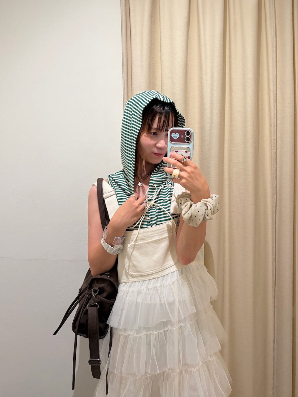 グリーン系のその他トップス、ホワイト系のジャンパースカート、レッド系のバッグを着用したレディースの夏コーディネートの2枚目の写真