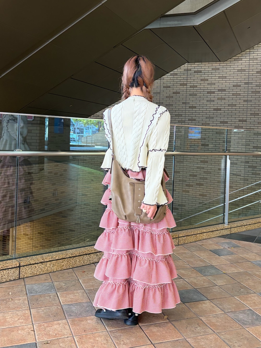 ホワイト系のカーディガン/ボレロ、レッド系のジャンパースカートを着用したレディースの春コーディネートの5枚目の写真