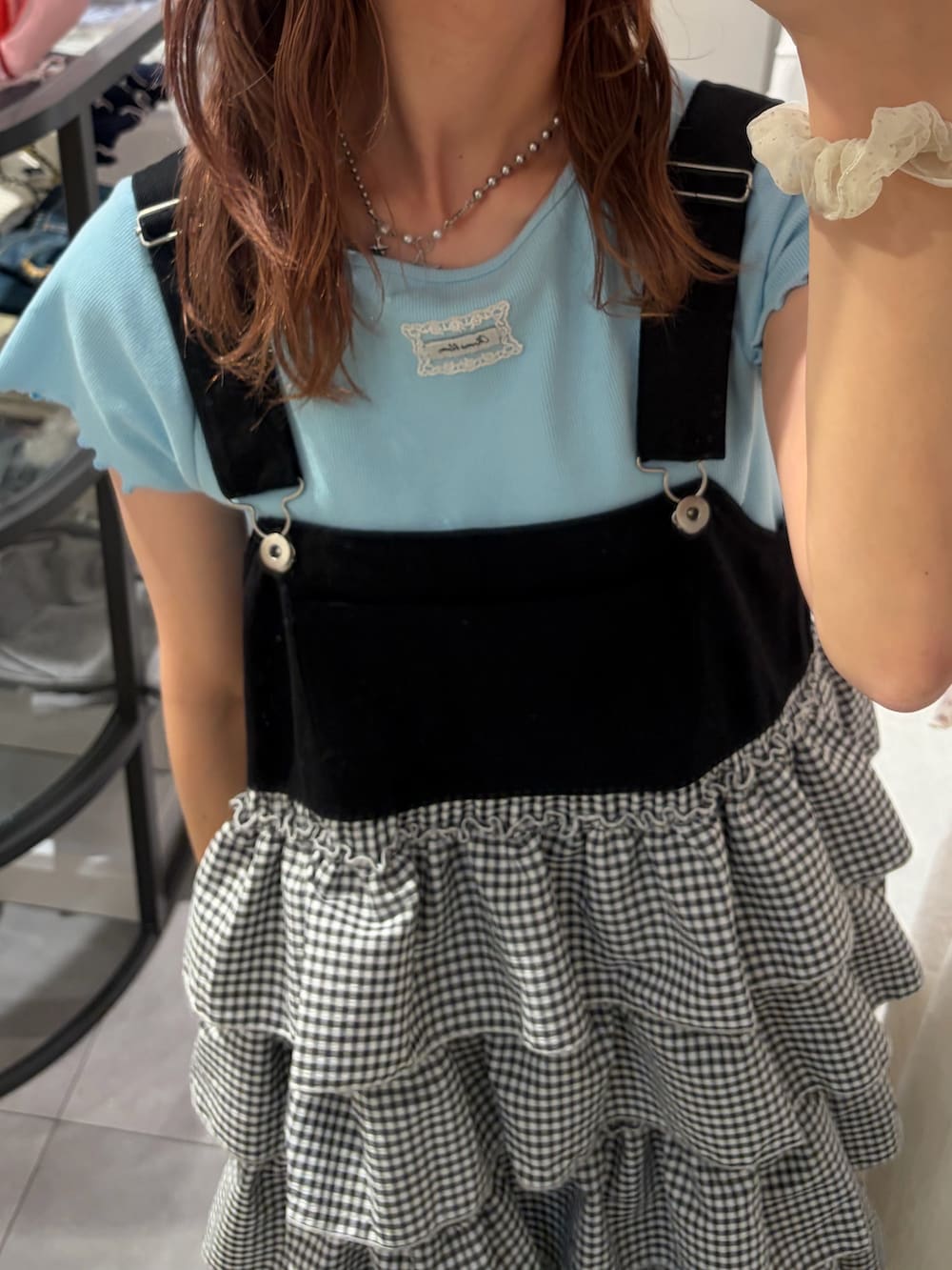 ブルー系のTシャツ/カットソー、ブラック系のジャンパースカートを着用したレディースの春コーディネートの2枚目の写真