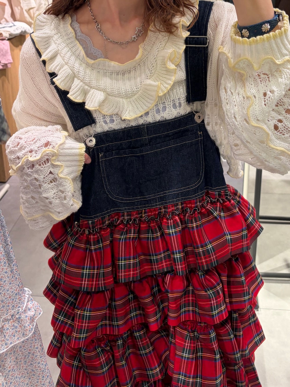 ホワイト系のパーカー、レッド系のジャンパースカートを着用したレディースの春コーディネートの4枚目の写真