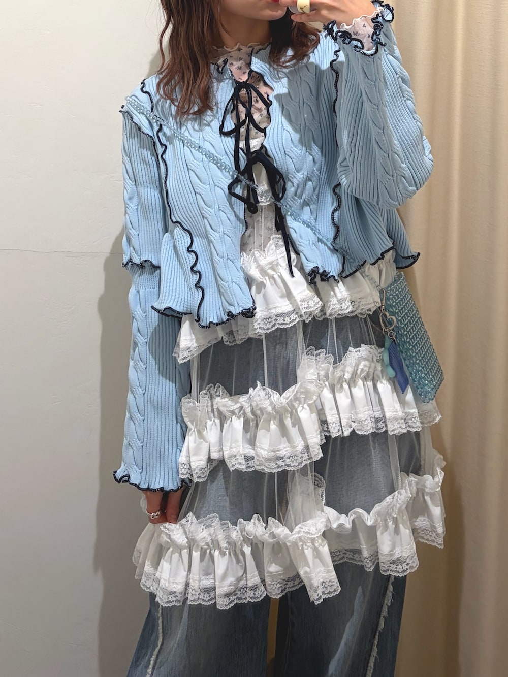 ホワイト系のワンピース、ブルー系のデニムパンツ、ブルー系のカーディガン/ボレロを着用したレディースの春コーディネートの3枚目の写真