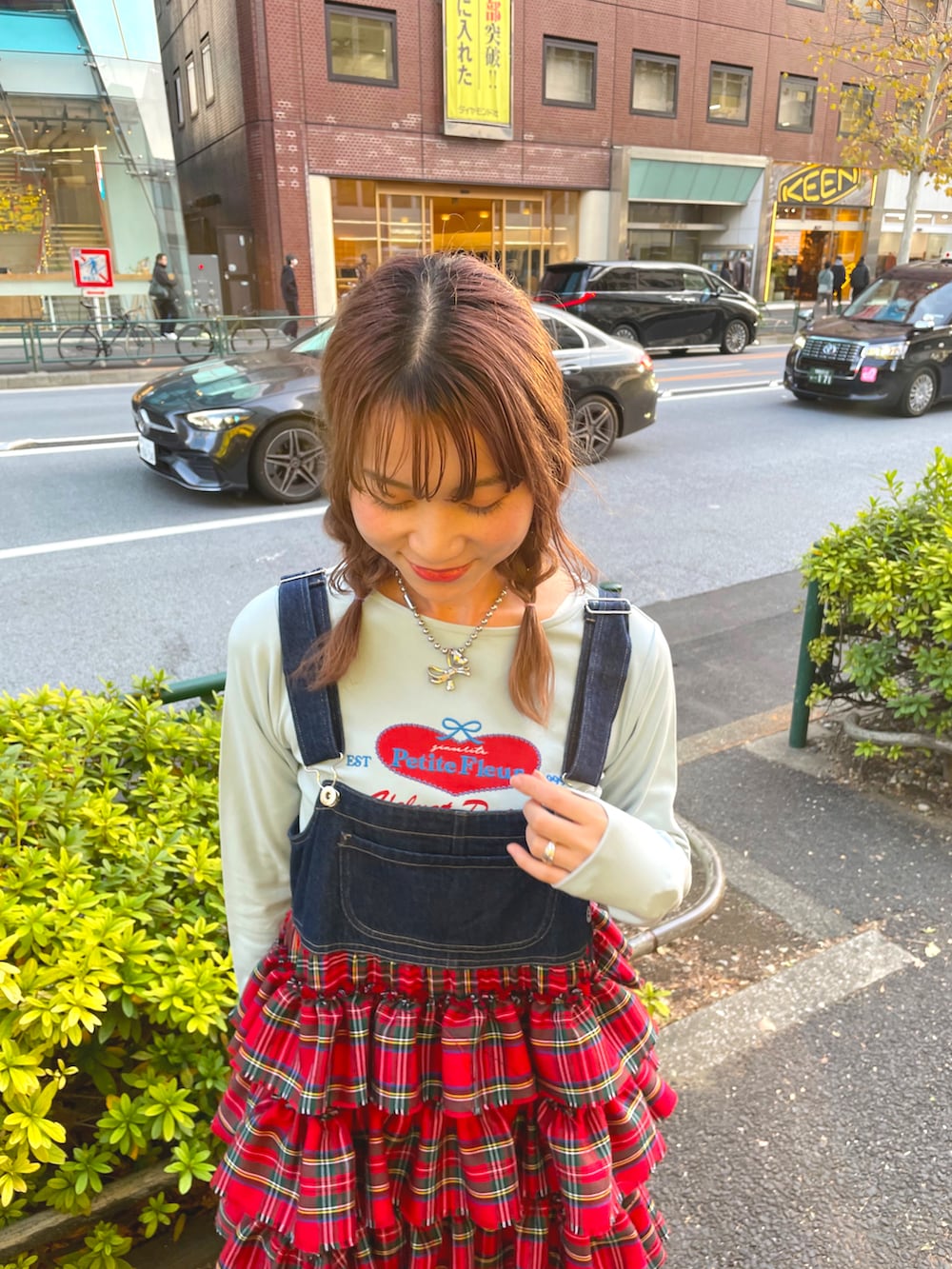 ブルー系のTシャツ/カットソー、レッド系のジャンパースカートを着用したレディースの冬コーディネートの2枚目の写真