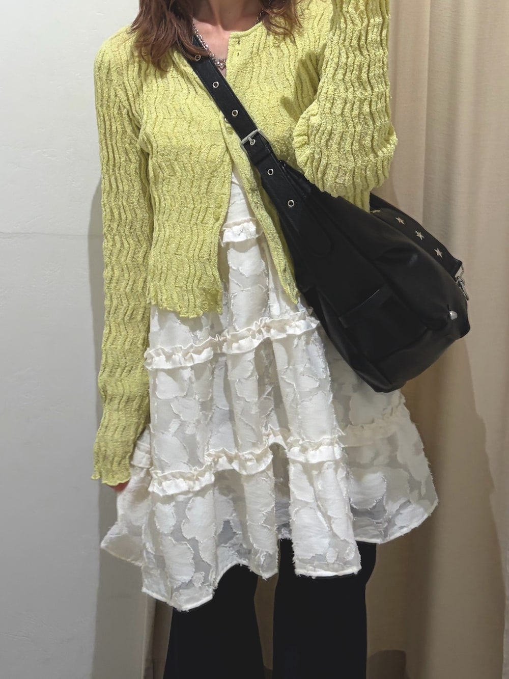 グリーン系のTシャツ/カットソー、ホワイト系のワンピース、ブルー系のデニムパンツを着用したレディースの春コーディネートの4枚目の写真