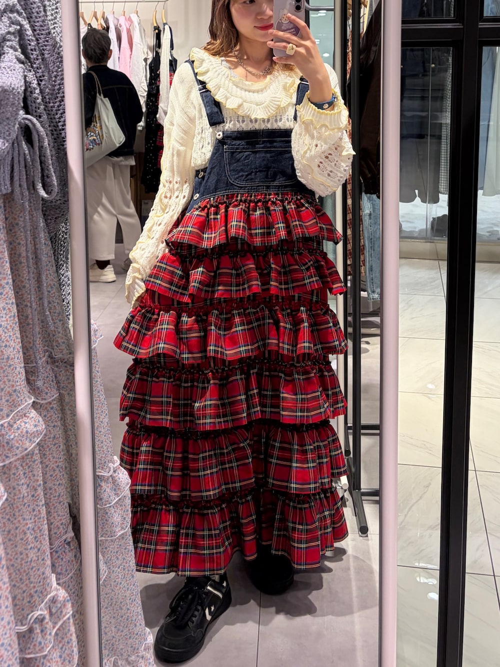 ホワイト系のパーカー、レッド系のジャンパースカートを着用したレディースの春コーディネートの3枚目の写真