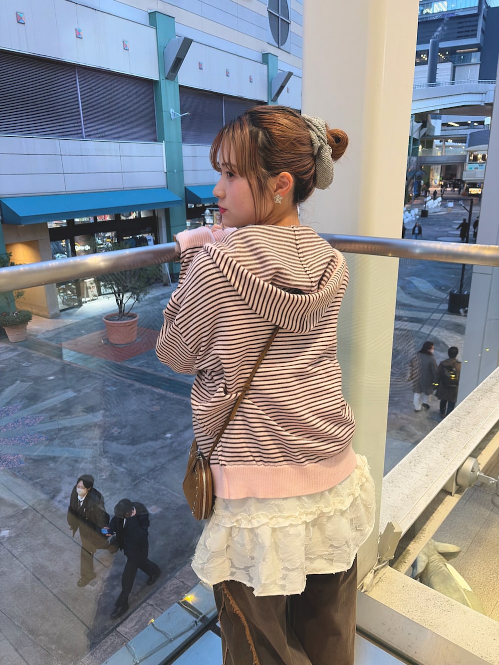 ピンク系のパーカー、イエロー系のトートバッグ、ホワイト系のワンピース/ドレスを着用したレディースの冬コーディネートの3枚目の写真