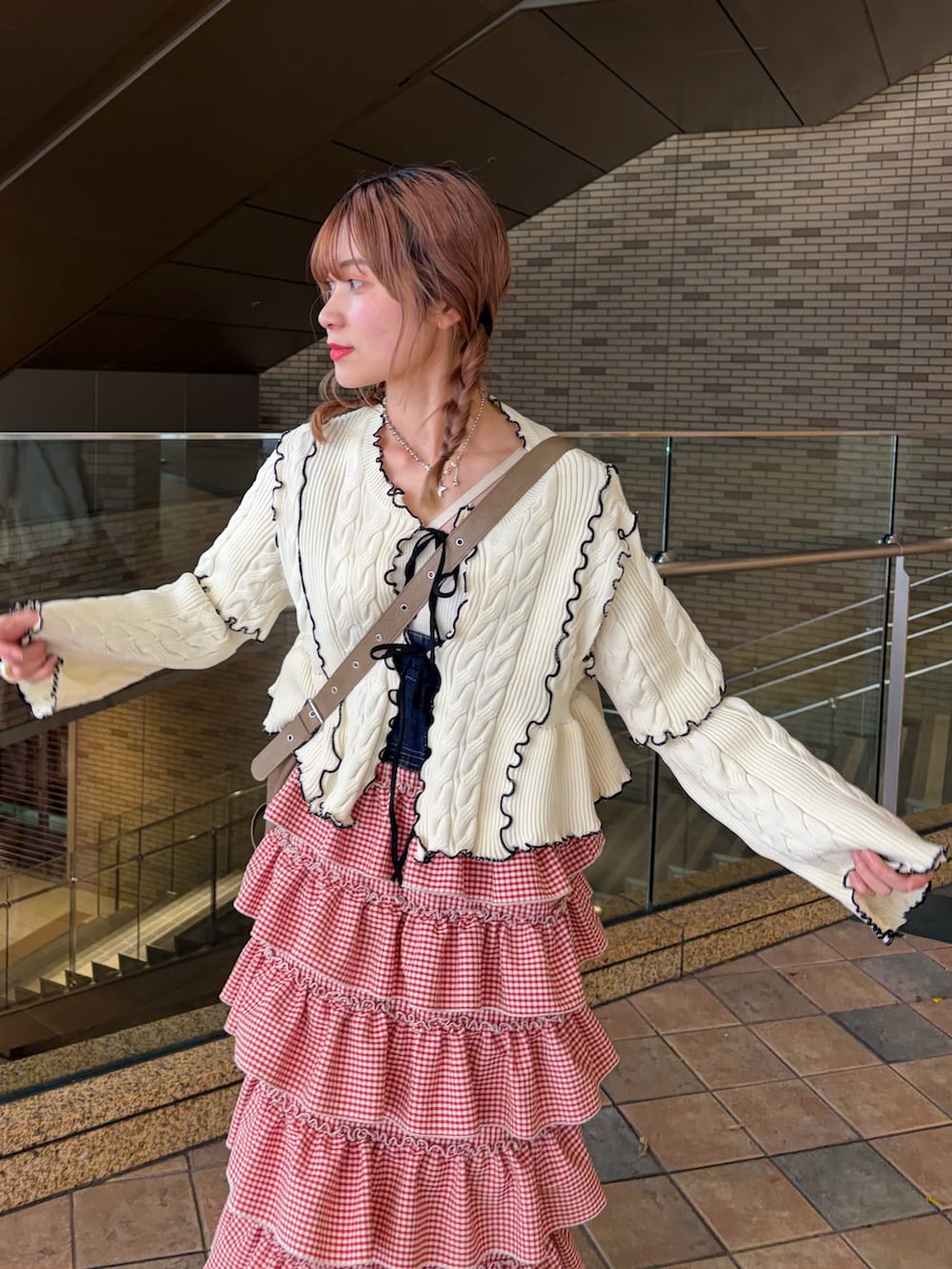 ホワイト系のカーディガン/ボレロ、レッド系のジャンパースカートを着用したレディースの春コーディネートの8枚目の写真