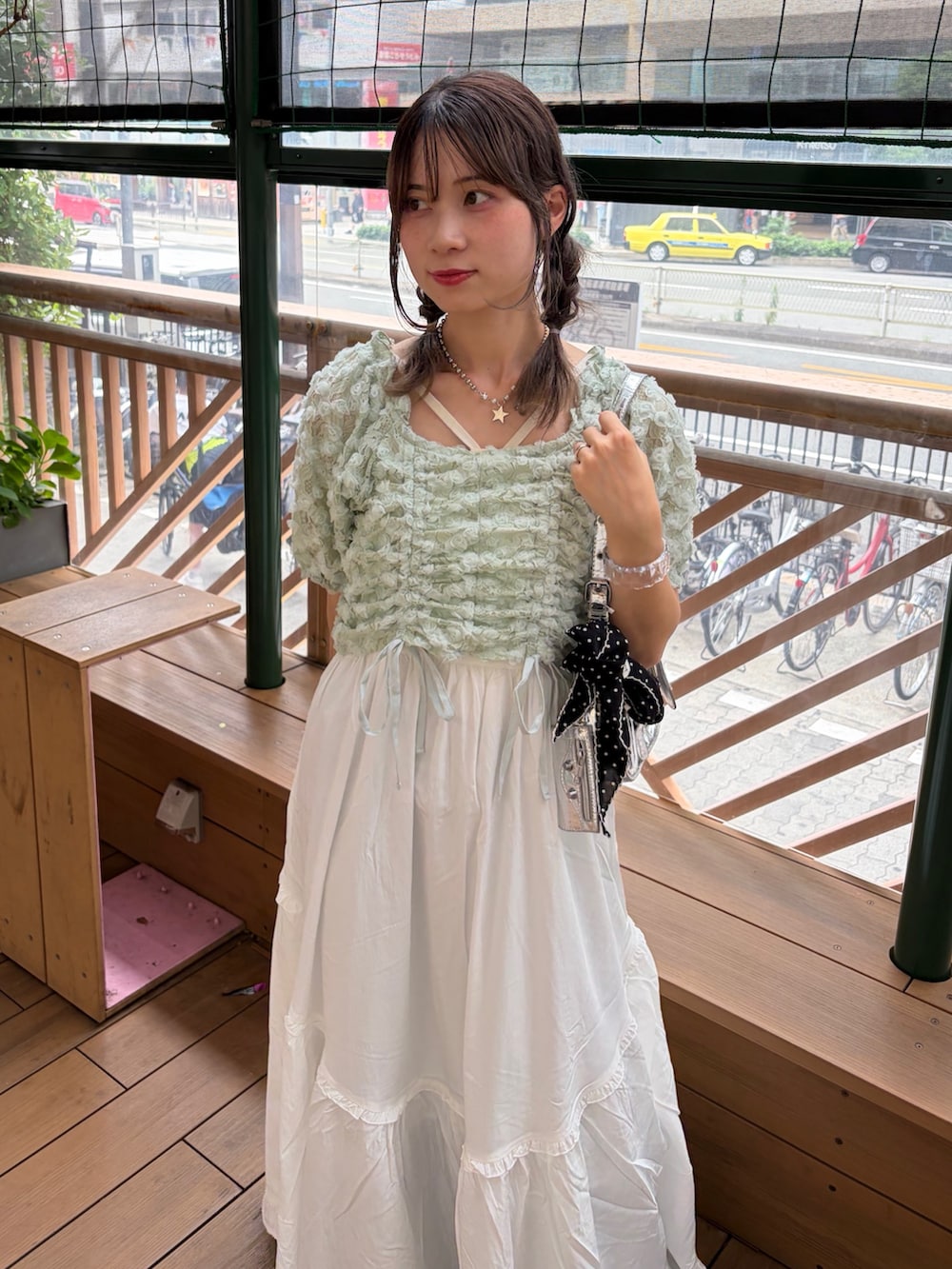 グリーン系のシャツ/ブラウス、ホワイト系のワンピース、ブルー系のデニムパンツを着用したレディースの夏コーディネートの4枚目の写真