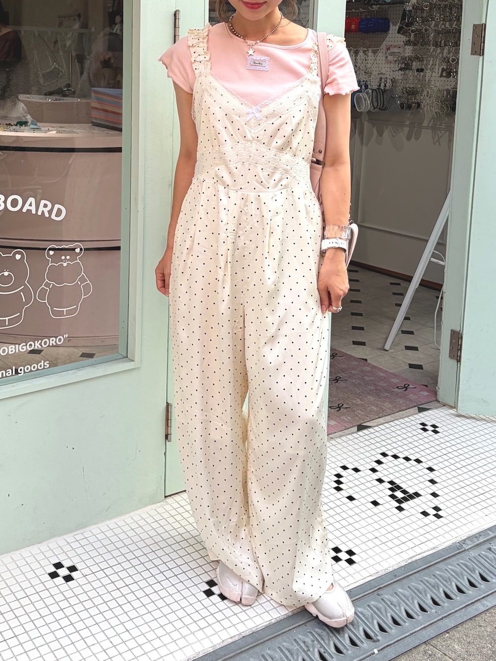 ピンク系のTシャツ/カットソー、ピンク系のボストンバッグ、ホワイト系のサロペット/オーバーオールを着用したレディースの夏コーディネートの2枚目の写真