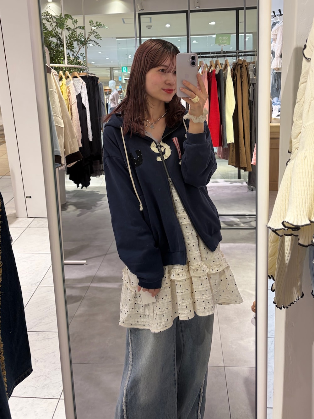 ブルー系のパーカー、ホワイト系のワンピース、ブルー系のデニムパンツを着用したレディースの春コーディネートの3枚目の写真
