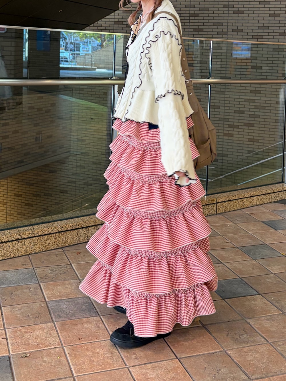 ホワイト系のカーディガン/ボレロ、レッド系のジャンパースカートを着用したレディースの春コーディネートの4枚目の写真