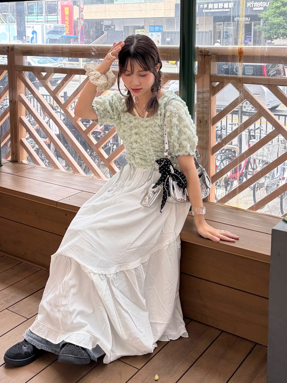 グリーン系のシャツ/ブラウス、ホワイト系のワンピース、ブルー系のデニムパンツを着用したレディースの夏コーディネートの3枚目の写真