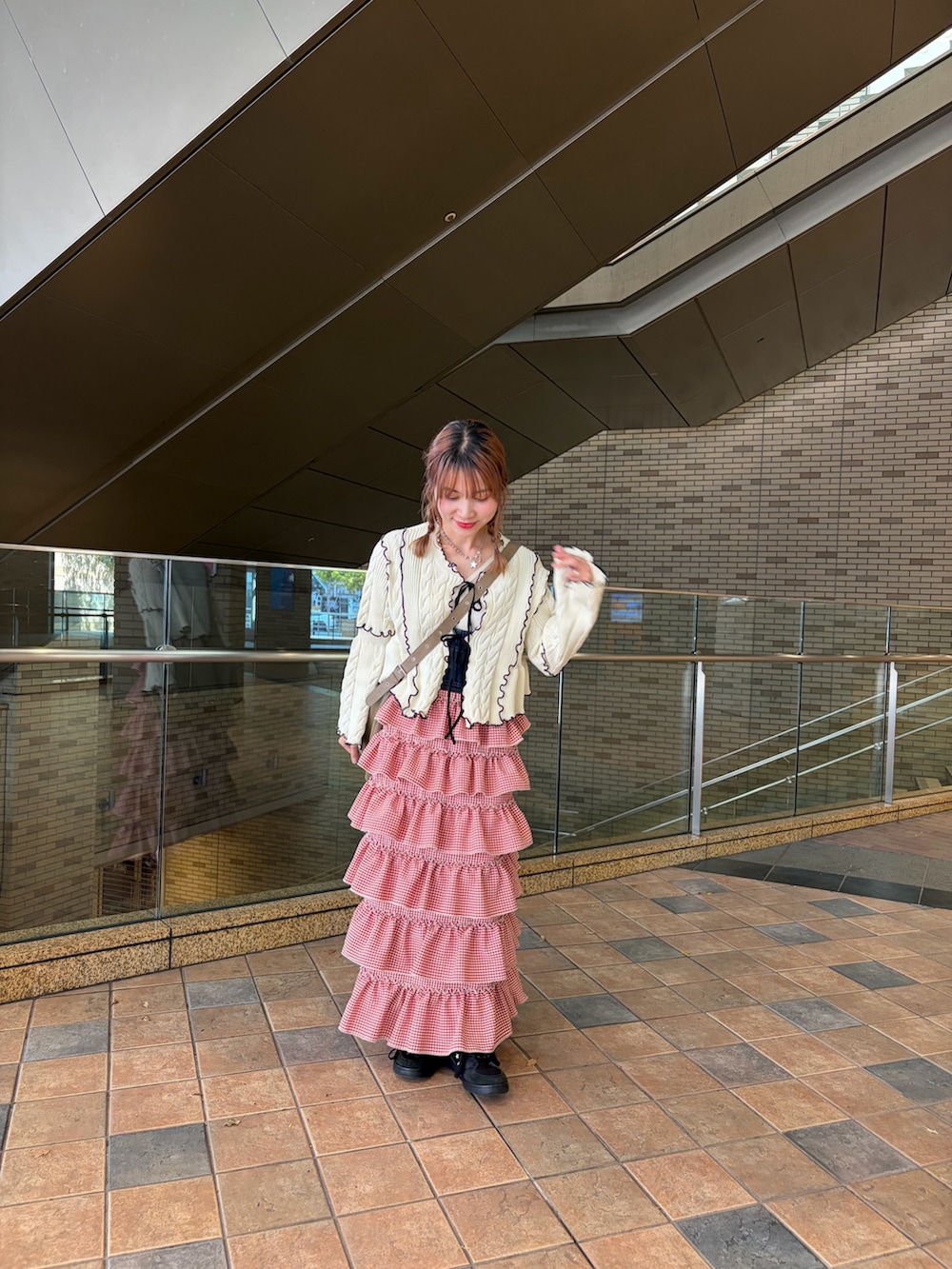 ホワイト系のカーディガン/ボレロ、レッド系のジャンパースカートを着用したレディースの春コーディネートの3枚目の写真