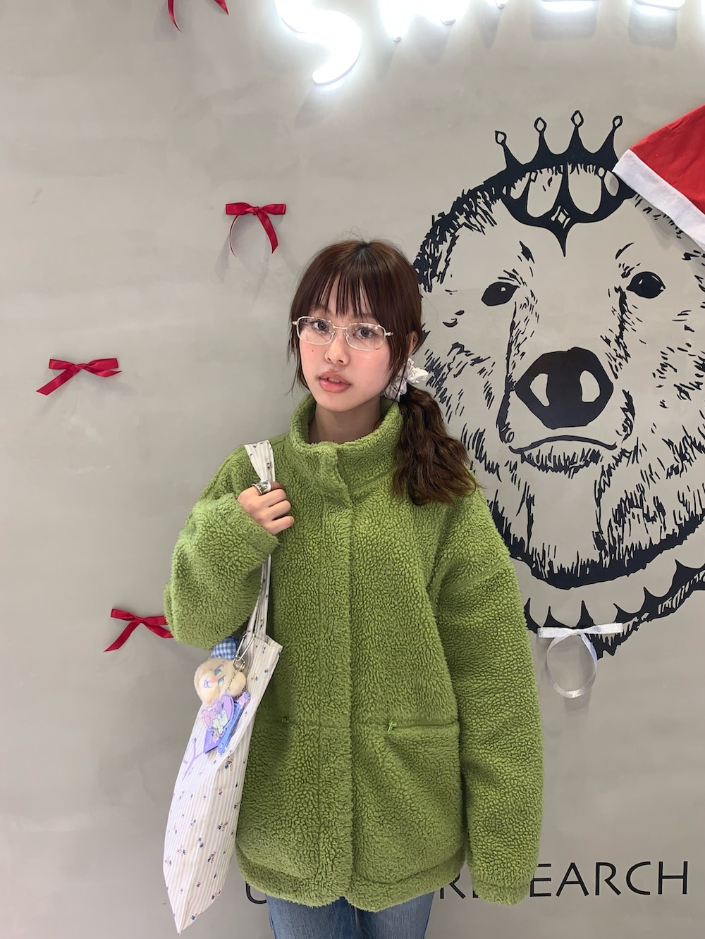 ベージュ系のトートバッグ、ゴールド系のメガネ、その他のシュシュを着用したレディースの冬コーディネートの2枚目の写真