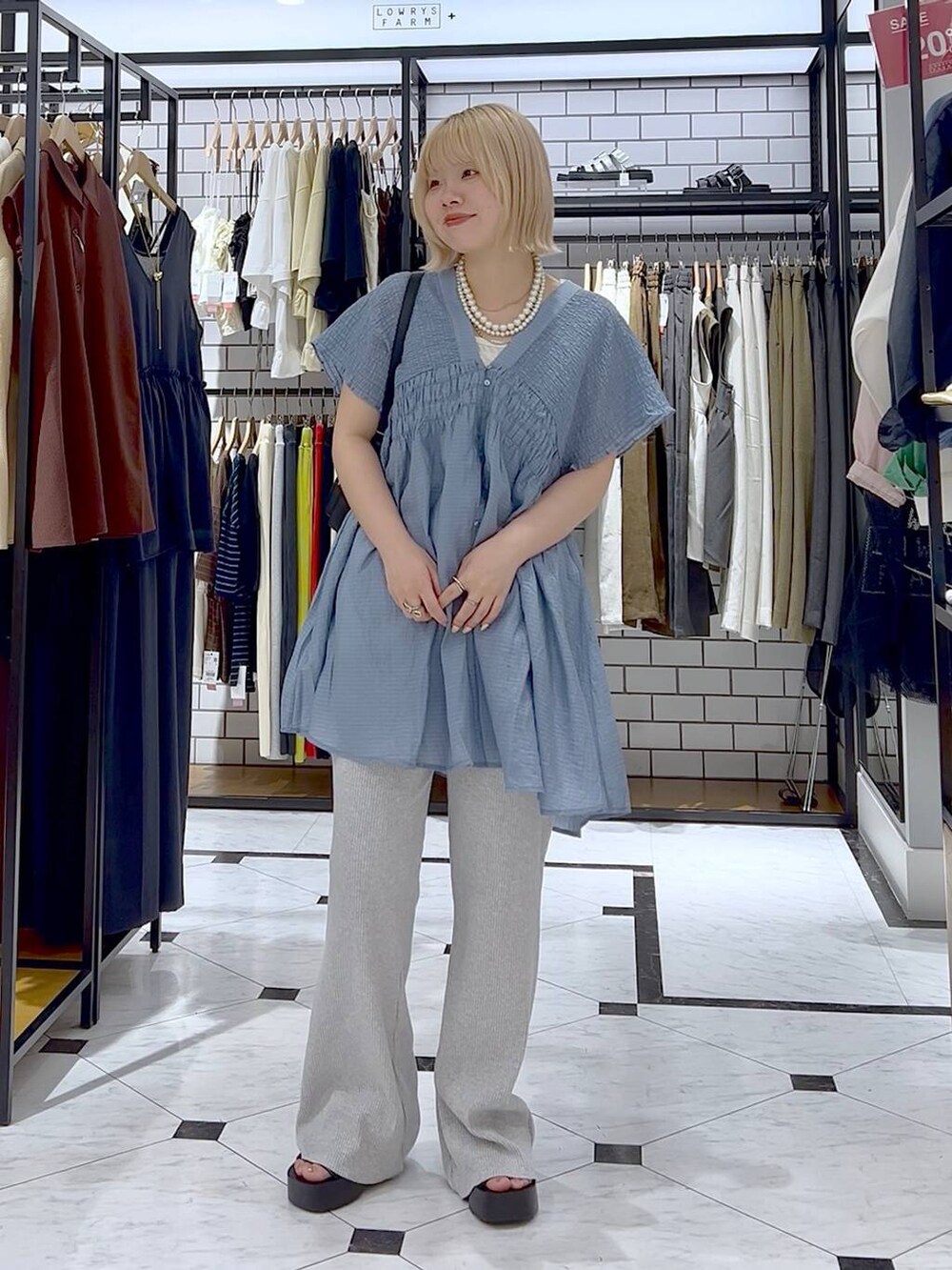 ホワイト系のタンクトップ、ブラック系のサンダル、ブラック系のショルダーバッグを着用したレディースの夏コーディネートの6枚目の写真