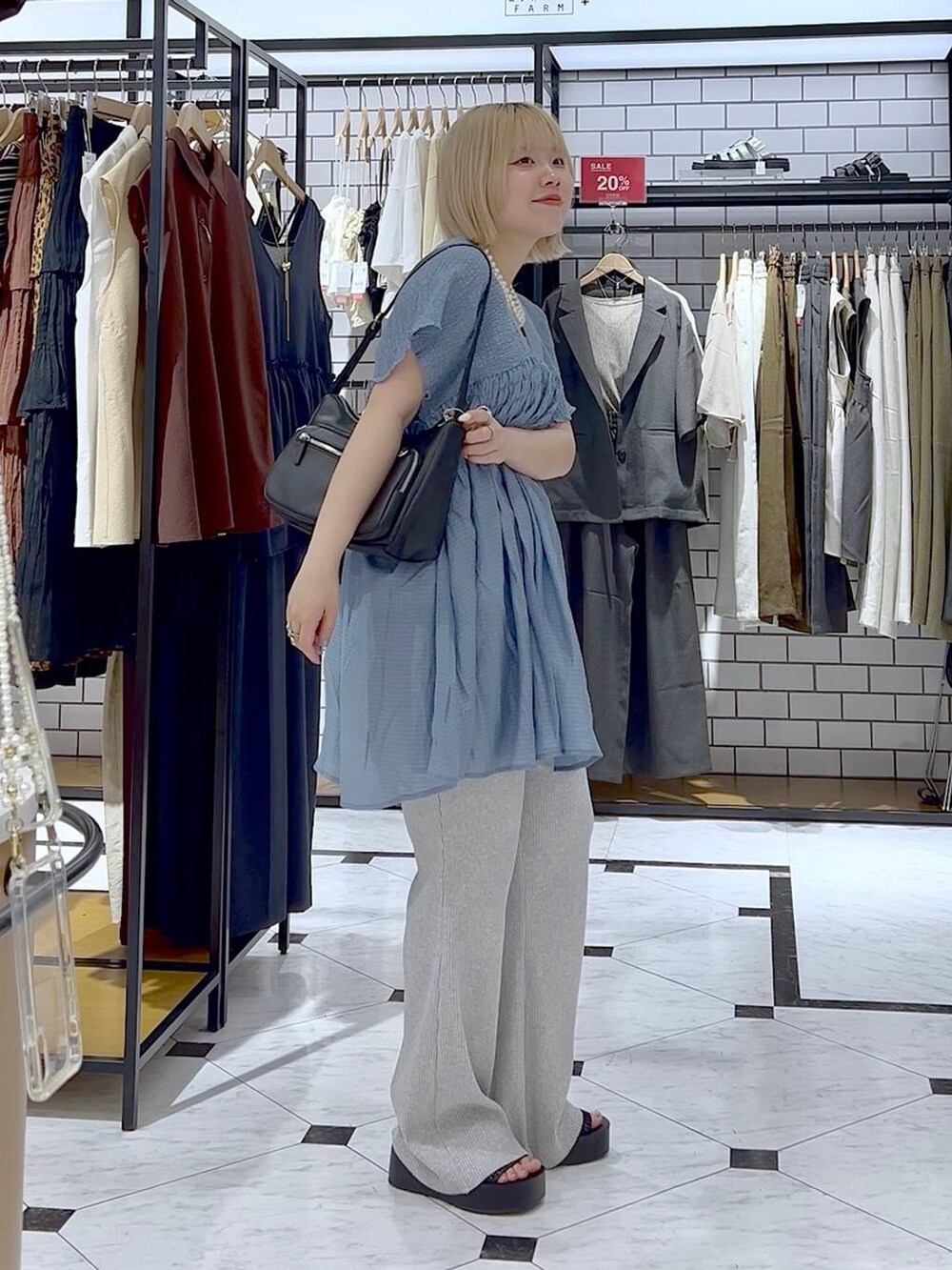 ホワイト系のタンクトップ、ブラック系のサンダル、ブラック系のショルダーバッグを着用したレディースの夏コーディネートの3枚目の写真