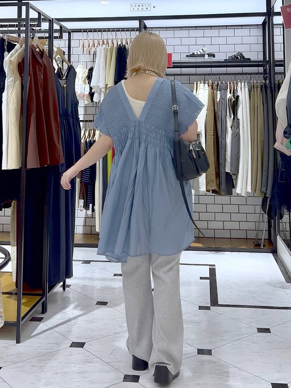 ホワイト系のタンクトップ、ブラック系のサンダル、ブラック系のショルダーバッグを着用したレディースの夏コーディネートの5枚目の写真