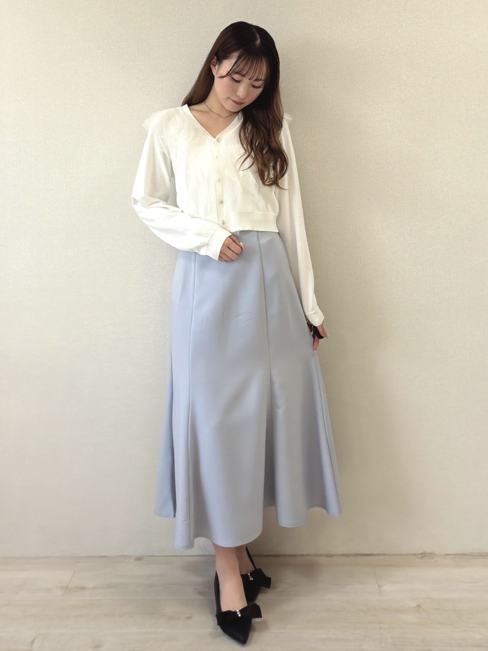 ブルー系のスカート、ブラック系のパンプスを着用したレディースの春コーディネートの2枚目の写真