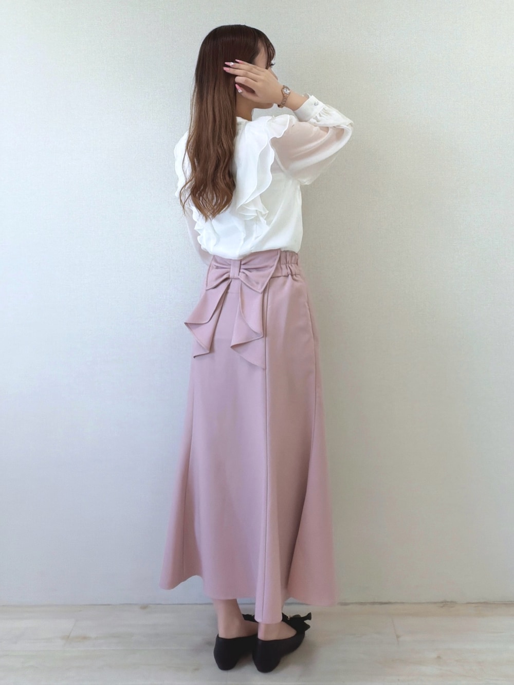 ホワイト系のシャツ/ブラウス、ピンク系のスカート、ブラック系のパンプスを着用したレディースの春コーディネートの2枚目の写真