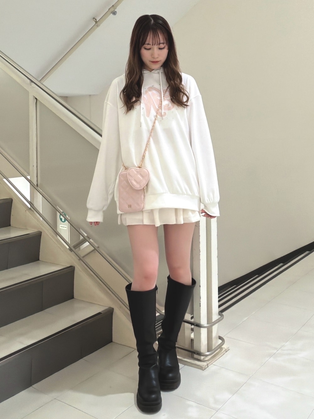 ホワイト系のスカート、ブラック系のブーツ、ホワイト系のパーカーを着用したレディースの冬コーディネートの2枚目の写真