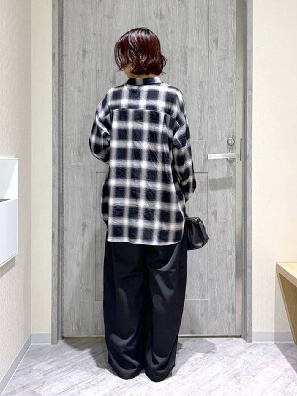 シルバー系のパンプス、ブラック系のボストンバッグ、ブラック系のその他パンツを着用したレディースの秋コーディネートの3枚目の写真