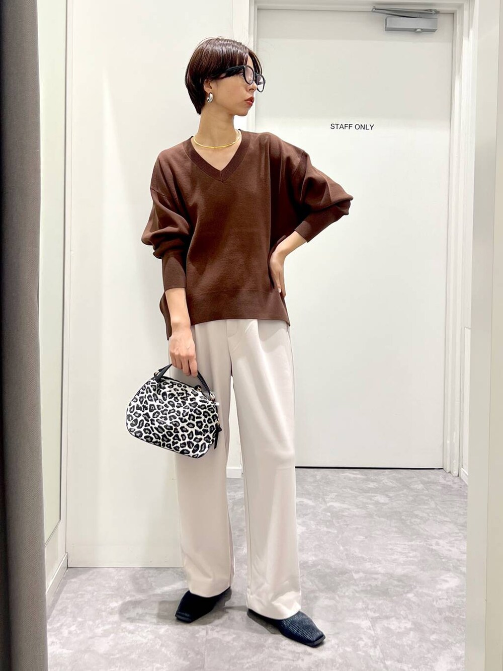 その他のショルダーバッグ、ブラウン系のスウェット、ホワイト系のその他パンツを着用したレディースの秋コーディネートの2枚目の写真