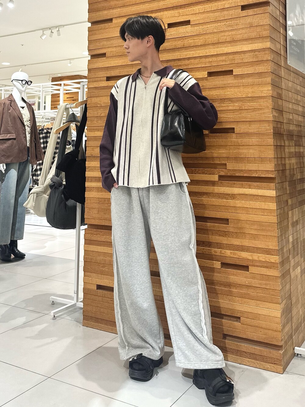 ホワイト系のニット/セーター、ブラック系のボストンバッグ、グリーン系のその他パンツを着用したメンズの秋コーディネートの2枚目の写真