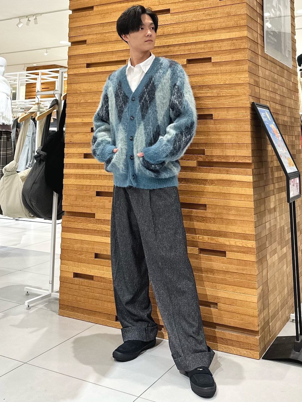 ホワイト系のシャツ/ブラウス、ブルー系のニット/セーター、ブラック系のスラックスを着用したメンズの秋コーディネートの2枚目の写真