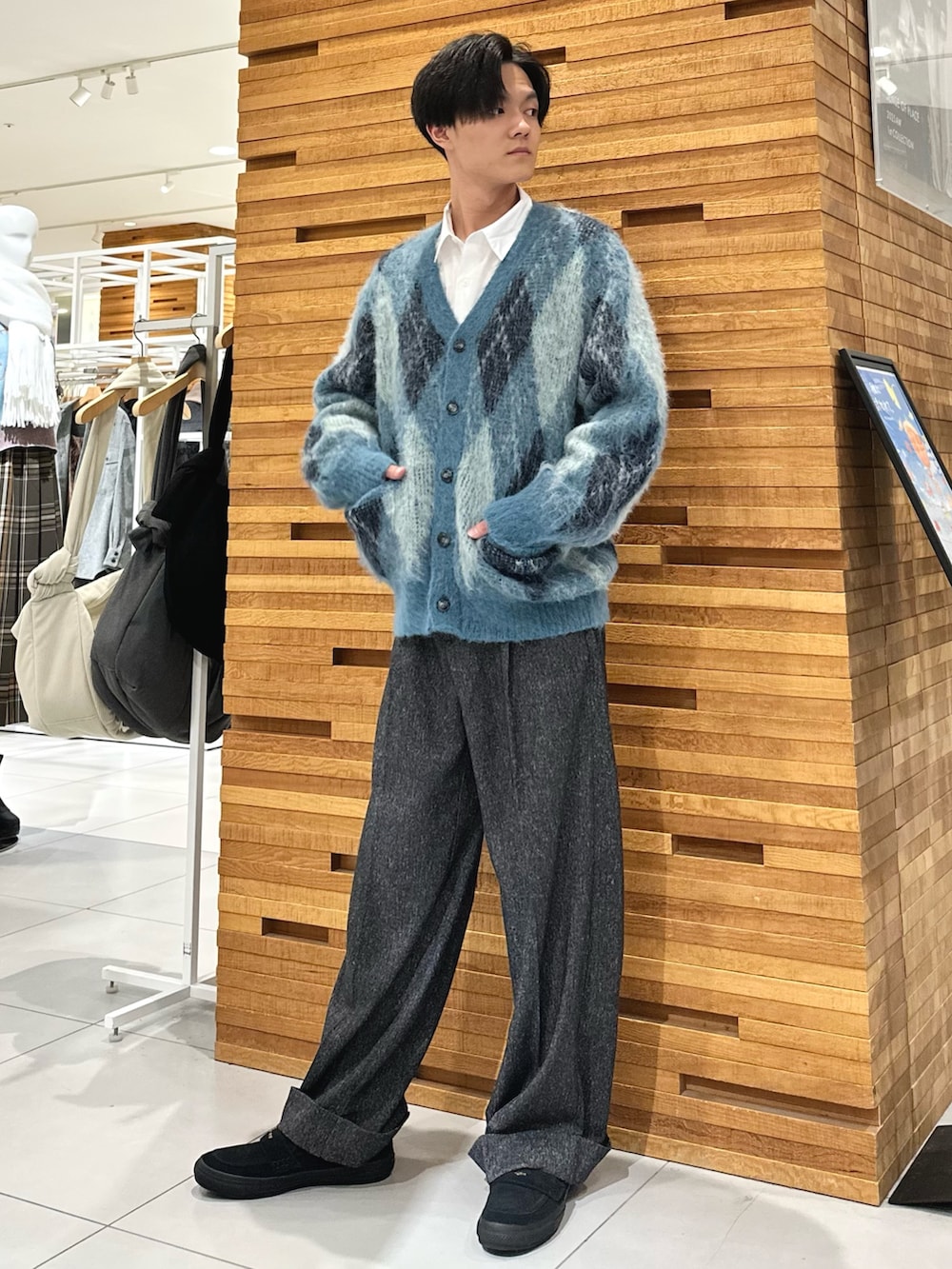 ホワイト系のシャツ/ブラウス、ブルー系のニット/セーター、ブラック系のスラックスを着用したメンズの秋コーディネートの3枚目の写真